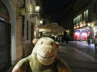 Mr Monkey walking down Celetná at night