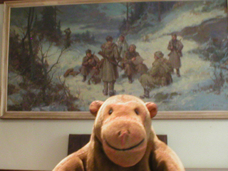 Mr Monkey looking at a painting of communist troops in the snow