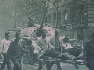 A photo of injured Prague citizens being carried past a Soviet tank