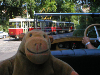 Mr Monkey in a car following a tram down Chotkova