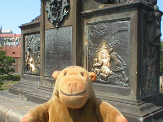 Mr Monkey looking at the plaques on the plinth of St John Nepomuk