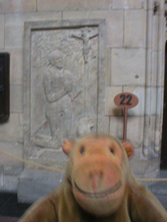 Mr Monkey looking at a knight's tombstone