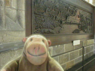 Mr Monkey looking at a wood relief showing Frederick fleeing Prague