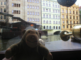 Mr Monkey looking at the buildings beside the Charles Bridge