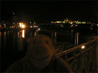Mr Monkey looking at Prague castle from Palackého bridge at night