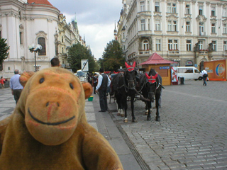 Mr Monkey looking at horse carriages in the Old Town Square
