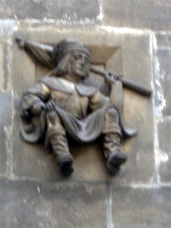 A carved man with a flag on the outside of the Powder Tower