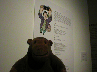 Mr Monkey reading a panel about the artist Kongkee