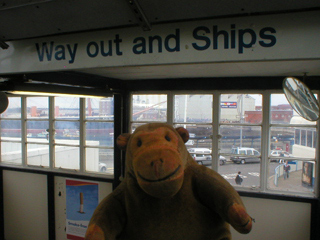 Mr Monkey looking at the 'Way Out and Ships' sign at Portsmouth