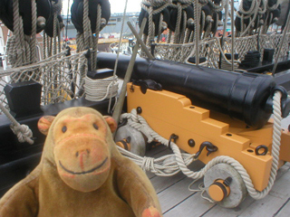 Mr Monkey looking at a 12 pounder on the forecastle