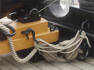 The ropes holding a 68 pounder carronade on the forecastle