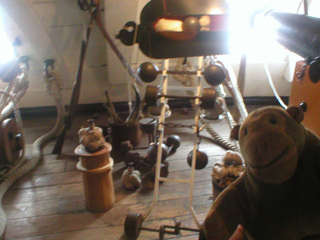 Mr Monkey looking at a display of different sorts of ammunition