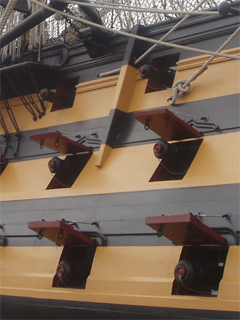The side of HMS Victory with guns rolled on on the lower, middle and upper gun decks