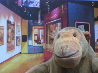 Mr Monkey in front of a picture of the Study in Sherlock gallery
