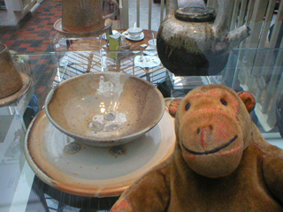 Mr Monkey looking at a plate, bowl and teapot by Sally Raven