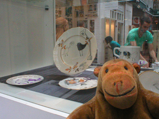 Mr Monkey looking at painted plates by Rachael Gardiner
