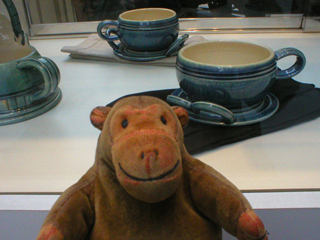 Mr Monkey looking at cups and saucers by Sean Gordon