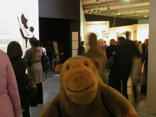 Mr Monkey and a crowd looking around the Emory Douglas exhibition
