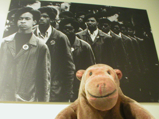Mr Monkey looking at a photo of uniformed Black Panthers
