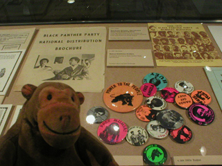 Mr Monkey looking at a collection of Black Panther badges