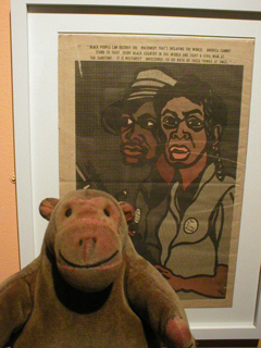 Mr Monkey looking at a poster urging black people to start a civil war in the USA