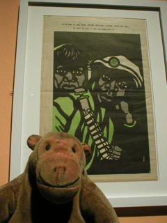 Mr Monkey looking at a poster recommending a violent response to government violence