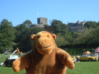 Mr Monkey with a row of cars and a castle behind him