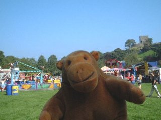 Mr Monkey in front of a small funfair