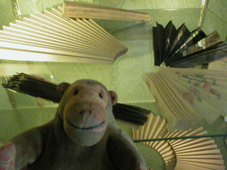 Mr Monkey looking at different ways of folding the leaf of a fan