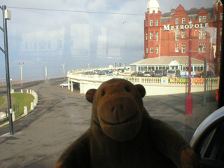Mr Monkey looking at the Grand Metropole Hotel from a bus