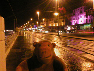 Mr Monkey walking through Blackpool at night