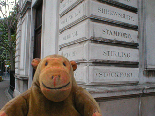 Mr Monkey reading the destinations carved on an old lodge of London Euston