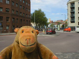 Mr Monkey looking at a car parked on a small traffic island