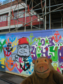Mr Monkey looking at street art on the Bristol Museum hoardings