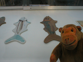 Mr Monkey looking at a row of ceramic fish