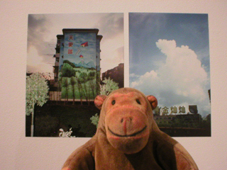 Mr Monkey looking at pictures of Shanghai buildings
