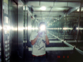 A Birdhead  member taking a photo in a mirrored lift