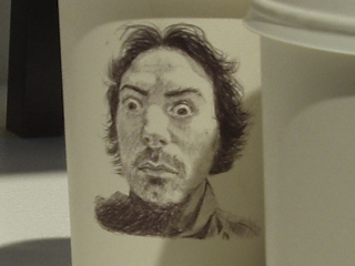 A self portrait on a styrofoam cup by Richard Shields of Contents May Vary