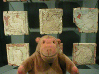 Mr Monkey looking at tiles from the medieval abbey