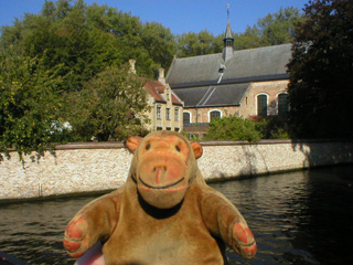 Mr Monkey looking at the Begijnhof across a canal 