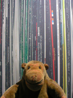 Mr Monkey looking at the giant record sleeves outside the exhibition