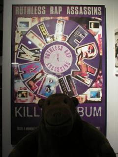 Mr Monkey looking at a Ruthless Rap Assassins' poster