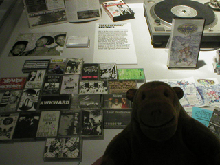 Mr Monkey looking at a collection of hip hop cassettes