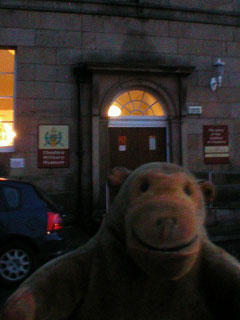 Mr Monkey outside the Cheshire Military Museum at dusk