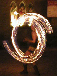 A fire dancer spinning flaming torches