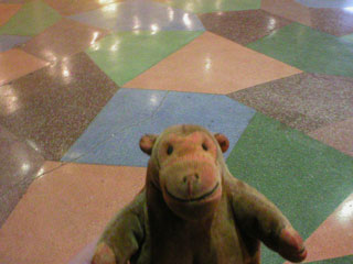 Mr Monkey looking at the lozenge patterned floor of the Winter Garden's foyer