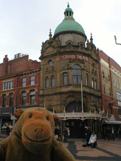 Mr Monkey looking at the Grand Theatre from across the street