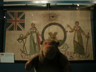 Mr Monkey looking at the Liverpool Tinplate Worker's banner