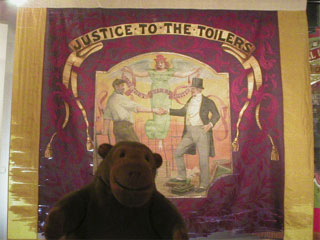 Mr Monkey looking at the back of the Ipswich Dockers Union banner
