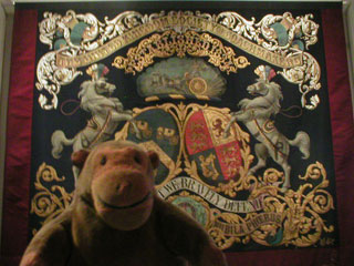 Mr Monkey looking at the banner of the United Kingdom Society of Coachmakers